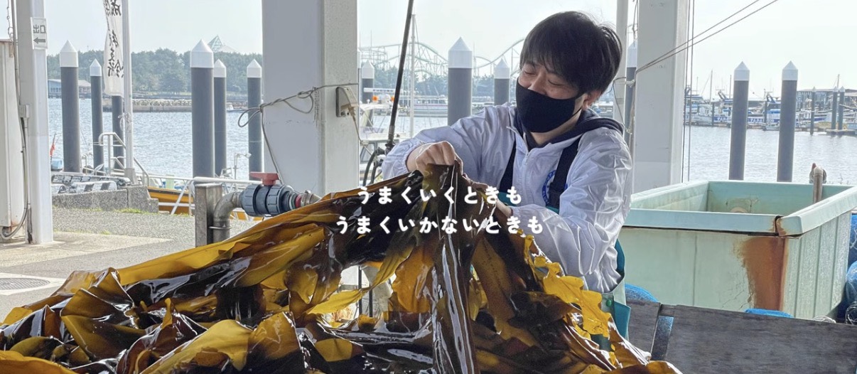 海の生き物をテーマにしたアート作品を囲む子どもたちと大人の集合写真